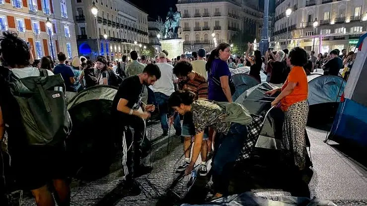 Los turistas conviven con el acampe por la vivienda en la Puerta del Sol